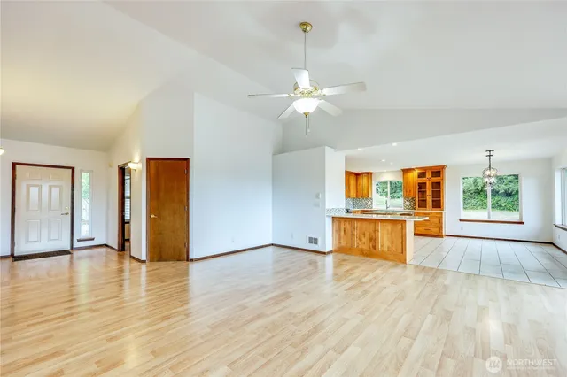 a view of an empty room with window and wooden floor