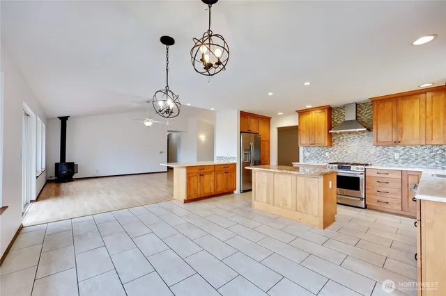 a kitchen with stainless steel appliances granite countertop a stove a sink and a refrigerator