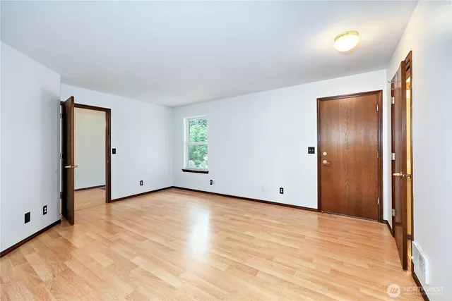 an empty room with windows and closet