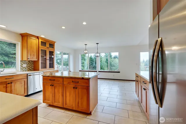 a kitchen with stainless steel appliances granite countertop a refrigerator and a sink