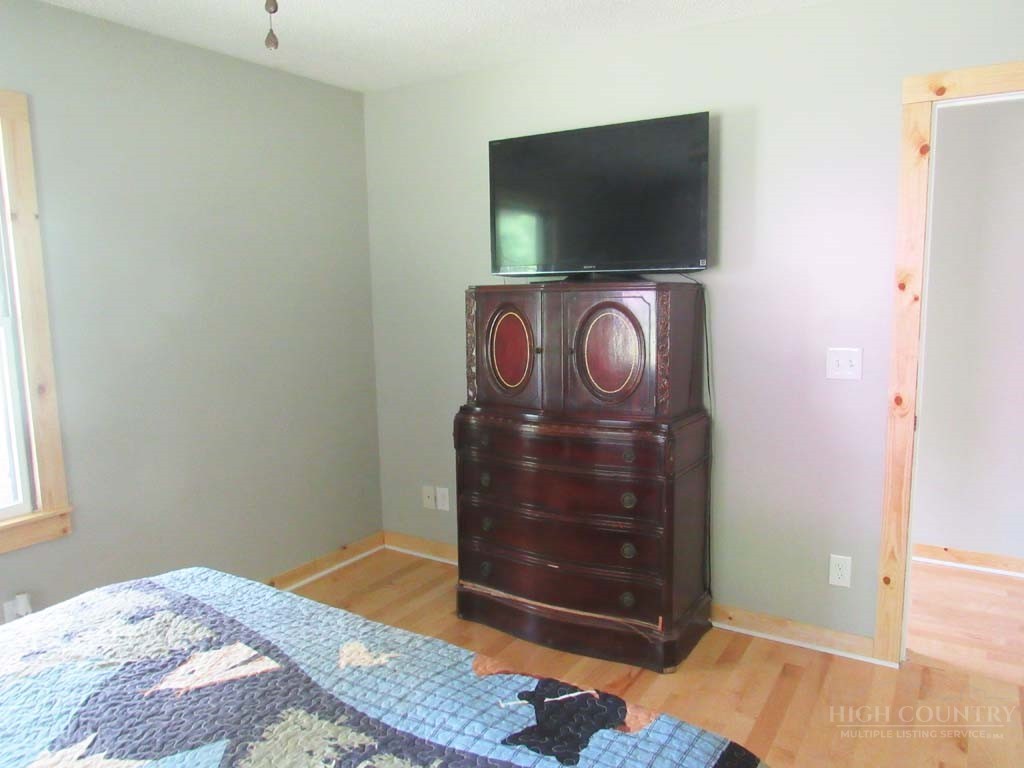 805 Ed Little Road Warrensville, NC 28693 - Photo 39 of 49 a bedroom with a bed and flat screen tv