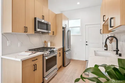 a kitchen with stainless steel appliances a stove a sink and a microwave