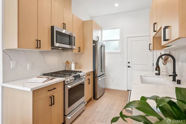 a kitchen with stainless steel appliances a stove a sink and a microwave