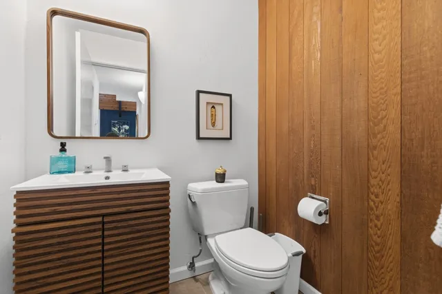 a bathroom with a sink a toilet and mirror