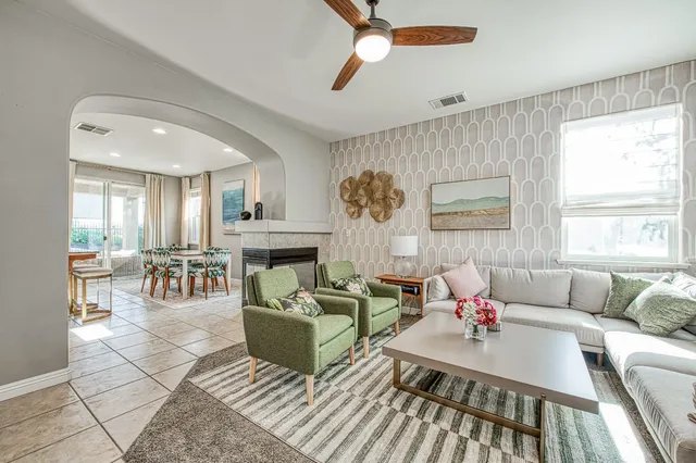 a living room with fireplace furniture and a large window