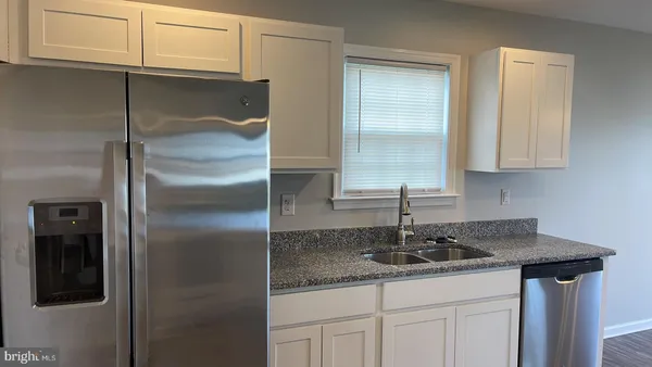 a kitchen with stainless steel appliances granite countertop a sink and cabinets