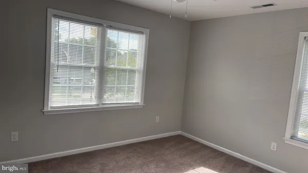 an empty room with closet and a chandelier fan