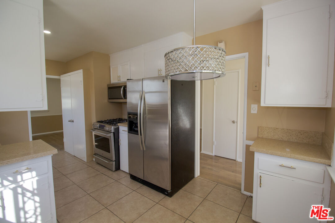 7465 North Forbes Ave Lake Lake Balboa, CA 91406 - Photo 4 of 13 a kitchen with stainless steel appliances granite countertop a refrigerator and a sink