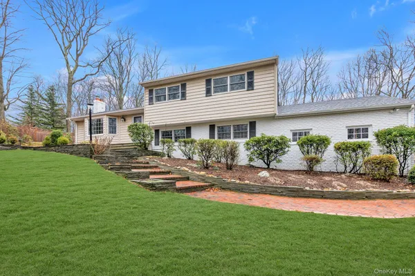 a front view of a house with a garden and patio