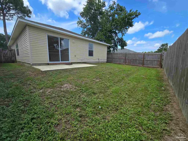 a view of backyard with wooden fence