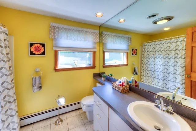 a bathroom with a sink mirror and a toilet