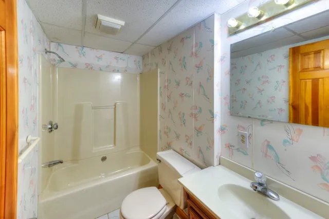 a bathroom with a sink toilet tub and shower