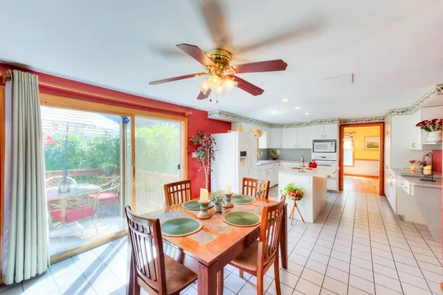a dining room with furniture a chandelier and a large window