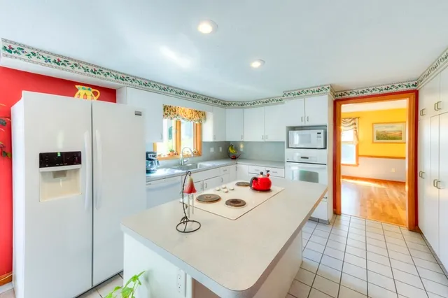 a very nice looking open kitchen with stainless steel appliances furniture cabinets and a wooden floor