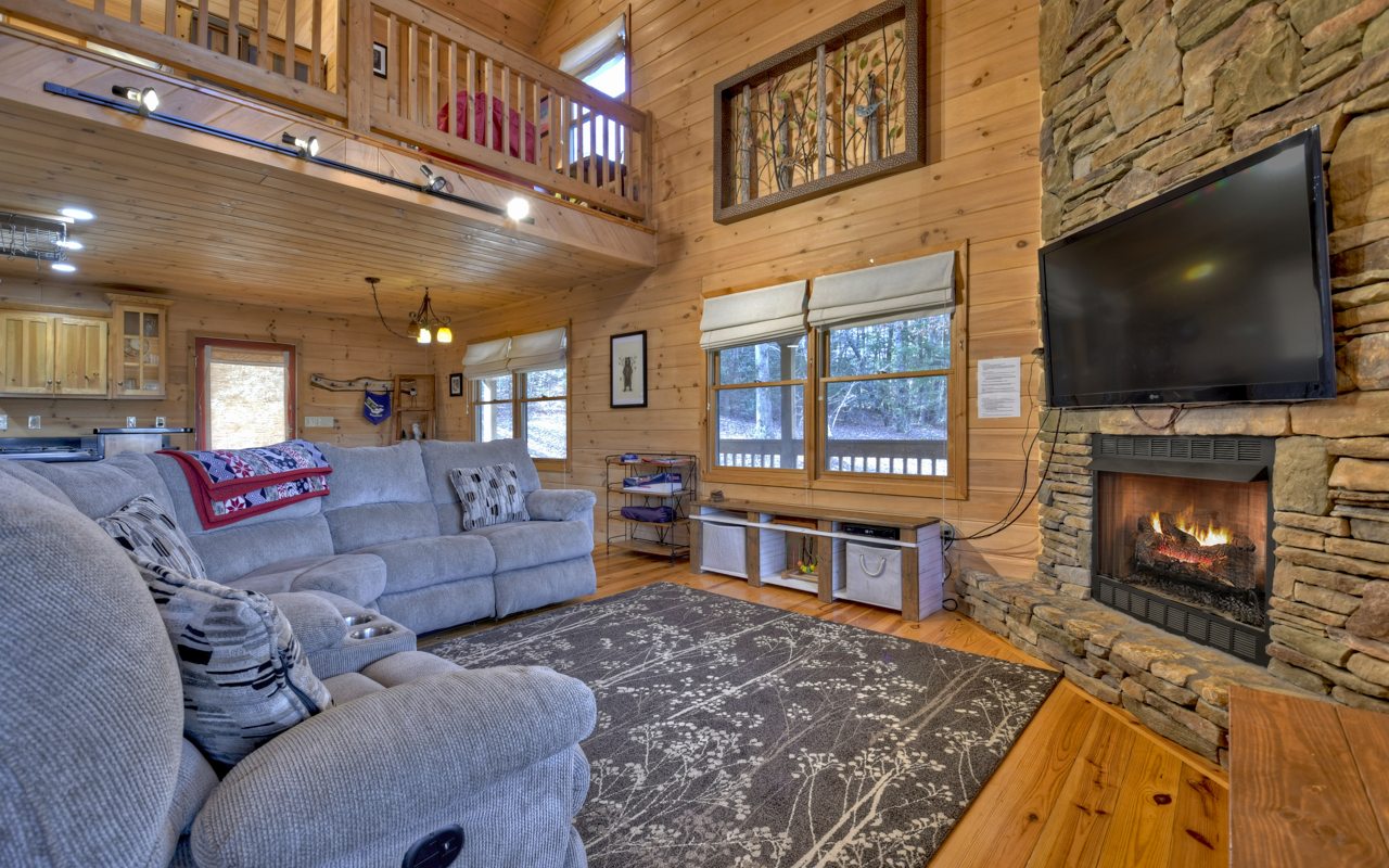 264 Sawmill Circle Blue Ridge, GA 30513 - Photo 12 of 39 a living room with furniture a flat screen tv and a fireplace