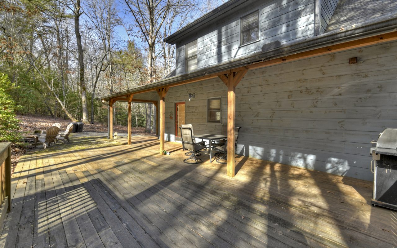 264 Sawmill Circle Blue Ridge, GA 30513 - Photo 32 of 39 a view of a patio with table and chairs and floor to ceiling window with wooden floor