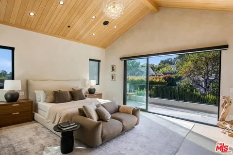 a bedroom with furniture and large windows