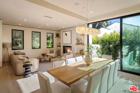 a living room with fireplace furniture and a large window