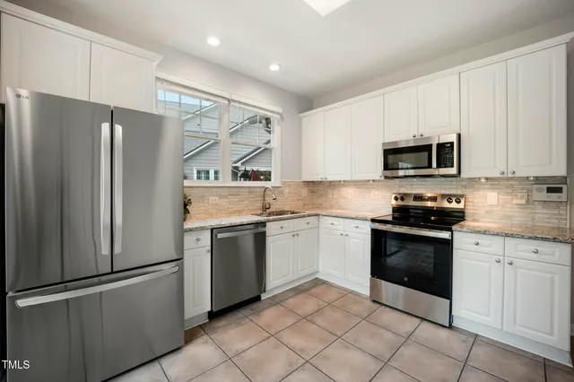 a view of an empty room with a fireplace and a window