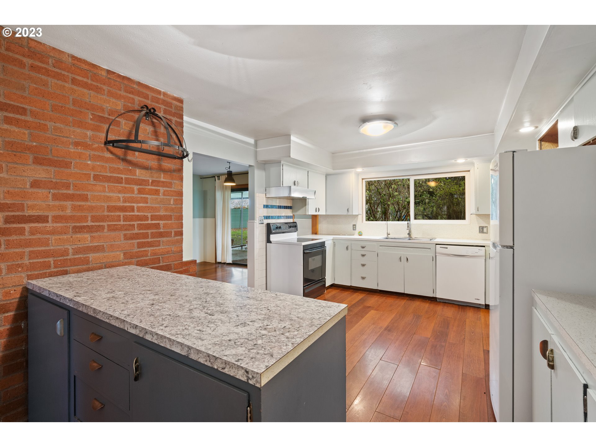 15200 Northwest Gillihan Road Portland, OR 97231 - Photo 16 of 42 a kitchen with stainless steel appliances kitchen island granite countertop a refrigerator and a sink