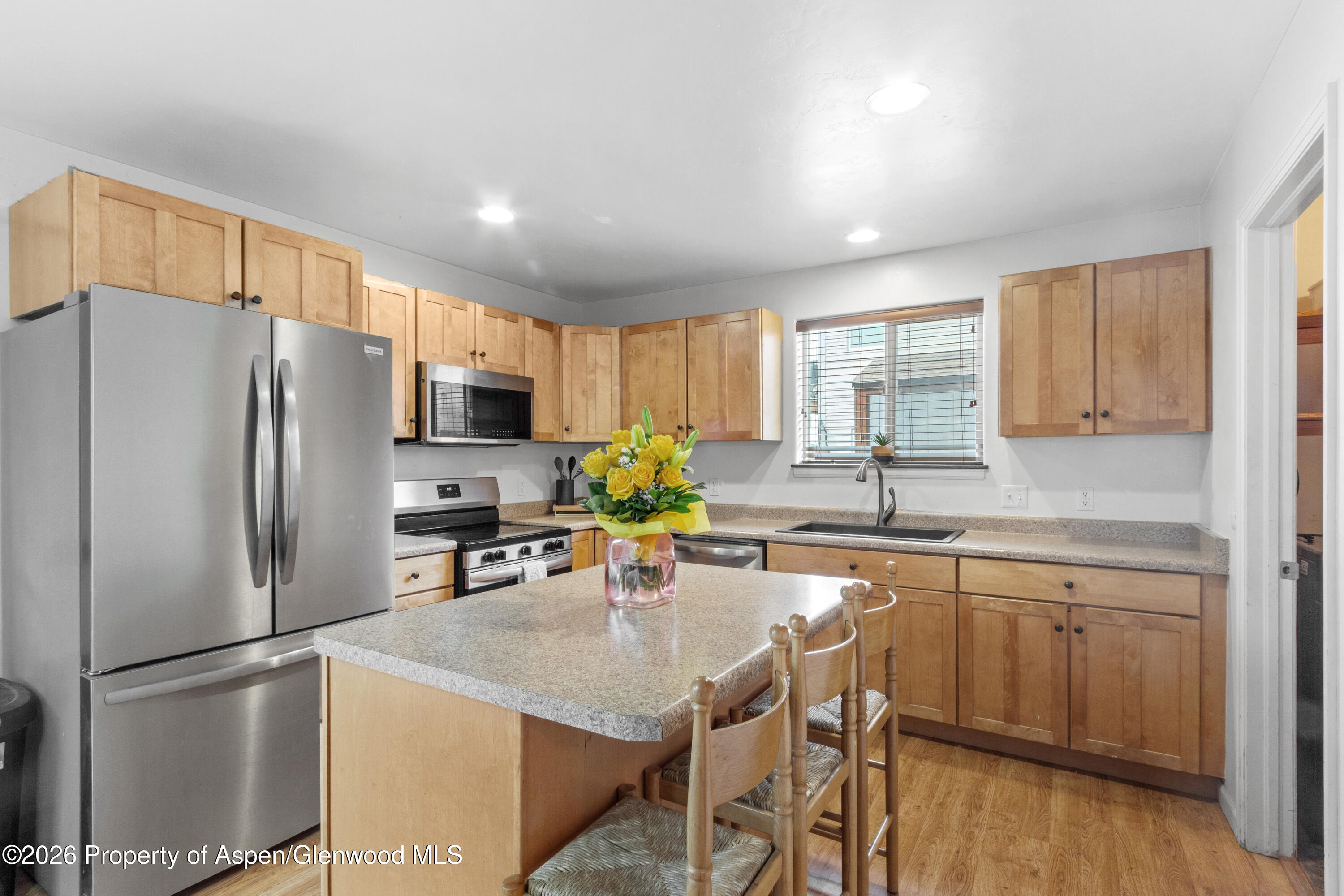 837 East 17th Street Rifle, CO 81650 - Photo 8 of 21 a kitchen with a refrigerator a sink a stove a dining table and chairs