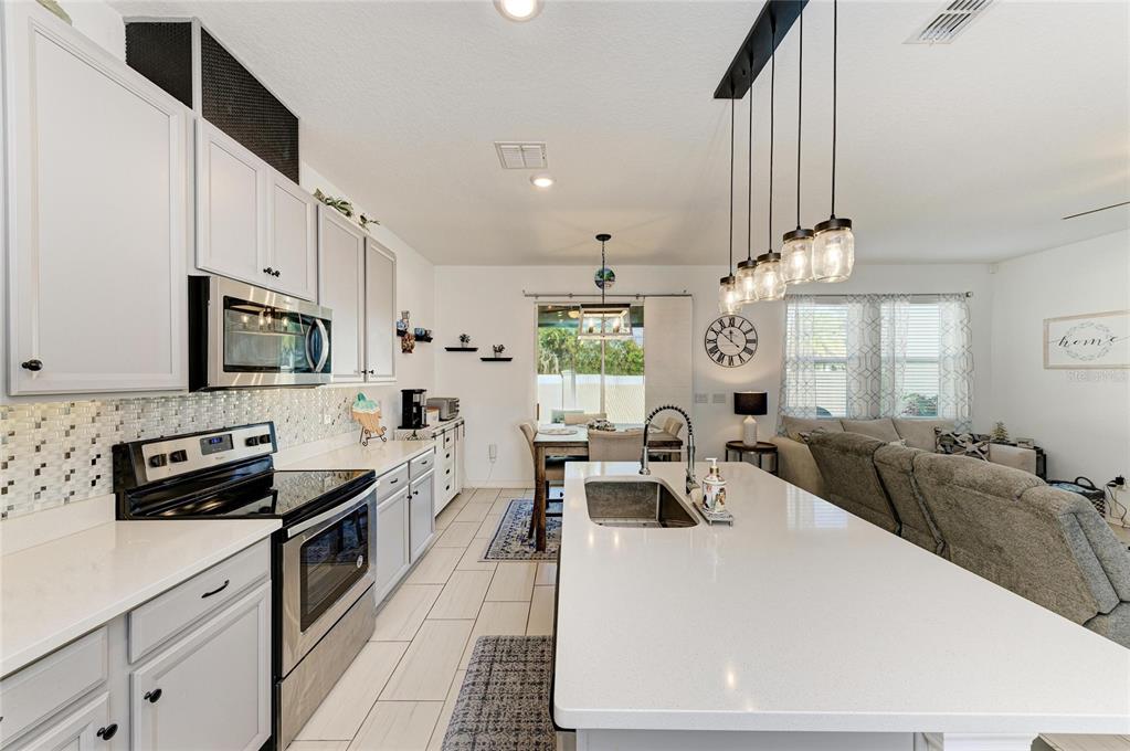 11637 Woodleaf Drive Lakewood Ranch, FL 34211 - Photo 14 of 54 a large white kitchen with stainless steel appliances