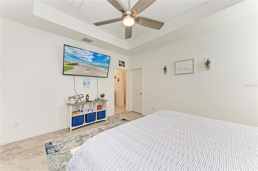 11637 Woodleaf Drive Lakewood Ranch, FL 34211 - Photo 21 of 54 a bedroom with a bed and a chandelier