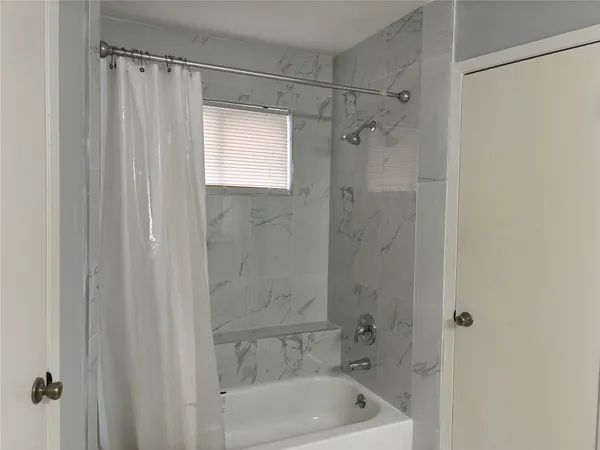 a bathroom with a shower and a bath tub
