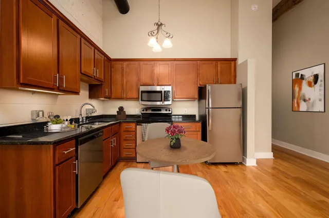 a kitchen with stainless steel appliances granite countertop a refrigerator a stove top oven a sink and dishwasher