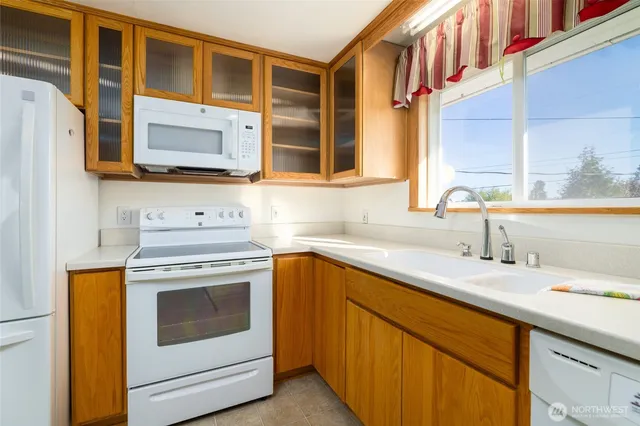 a kitchen with stainless steel appliances granite countertop a sink and a microwave