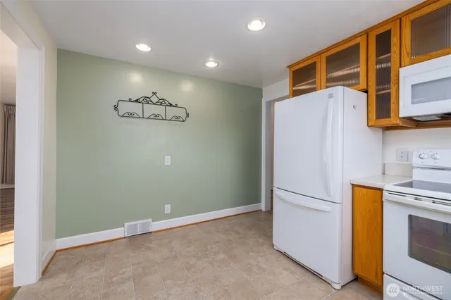 a view of kitchen with white cabinets and stainless steel appliances