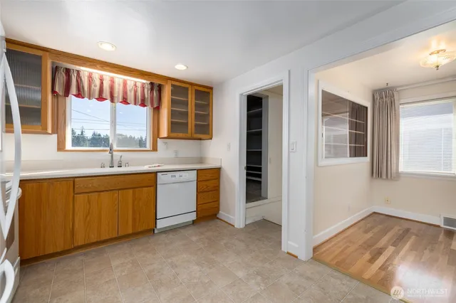 a kitchen with stainless steel appliances granite countertop a sink and cabinets with wooden floor