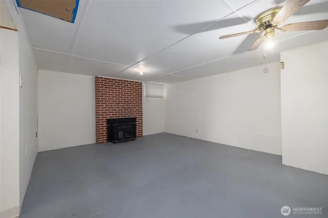 a view of an empty room with a fireplace and a fan