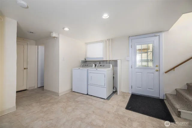 a utility room with cabinets washer and dryer