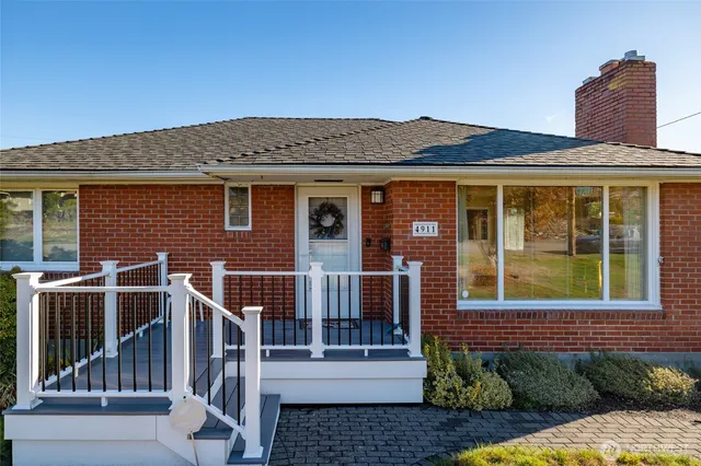 a view of a house with a small yard and wooden floor and fence