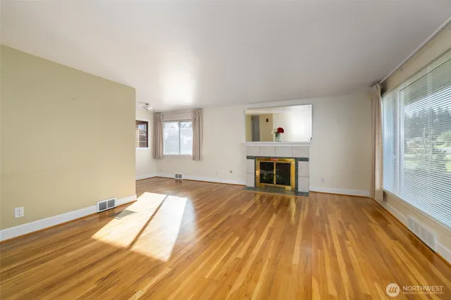 a view of empty room with wooden floor and fireplace