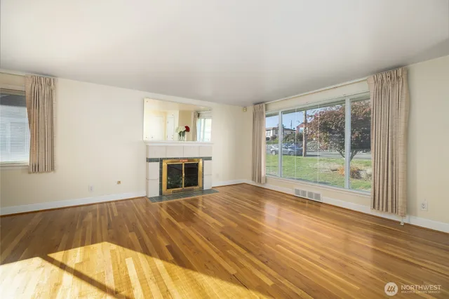 a view of empty room with wooden floor and fireplace