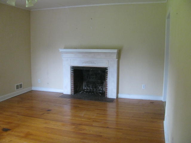 5515 Cove Road Roanoke, VA 24019 - Photo 8 of 25 a view of an empty room with wooden floor and a fireplace