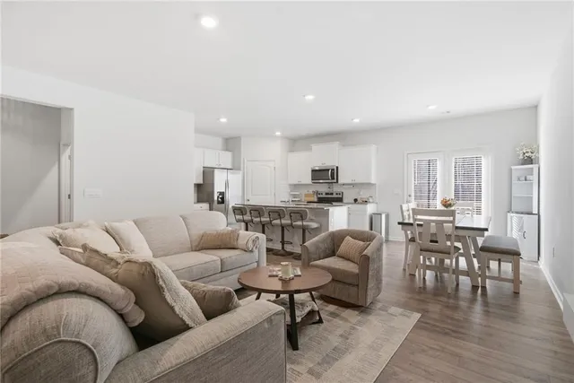 a kitchen with stainless steel appliances granite countertop a refrigerator a stove top oven a sink dishwasher and white cabinets with wooden floor