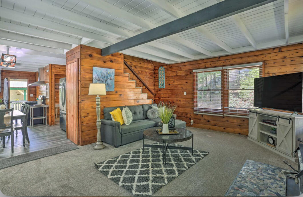 42036 Tollhouse Road Shaver Lake, CA 93664 - Photo 10 of 30 a living room with furniture a flat screen tv and a floor to ceiling window