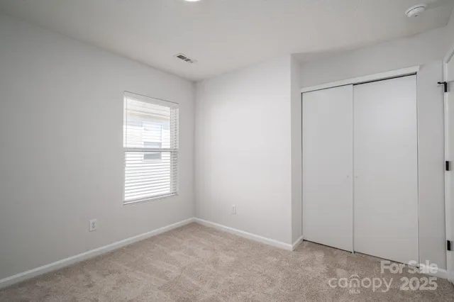 an empty room with windows and closet