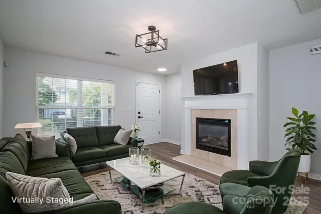 a living room with furniture a flat screen tv and a fireplace