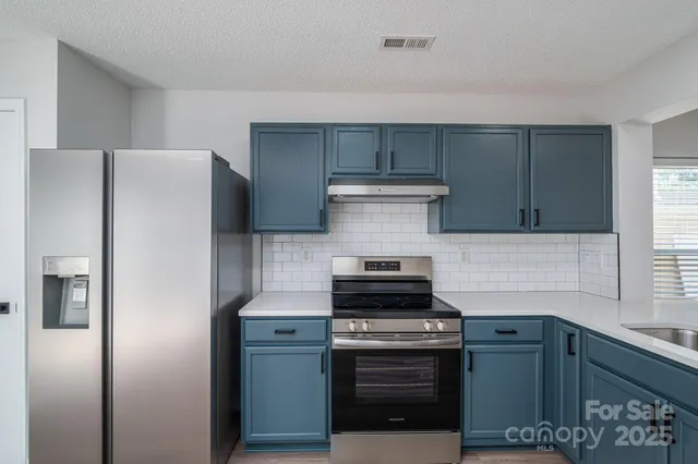 a kitchen with a stove and a refrigerator