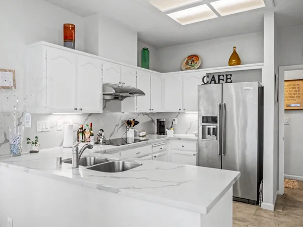 a kitchen with stainless steel appliances granite countertop a refrigerator and a sink