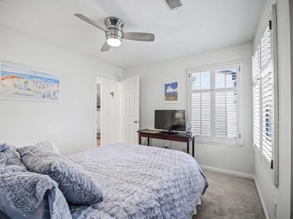 a bedroom with a bed a window and a flat screen tv