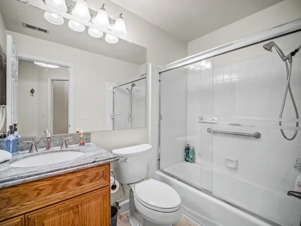 a bathroom with a sink a toilet a mirror and shower