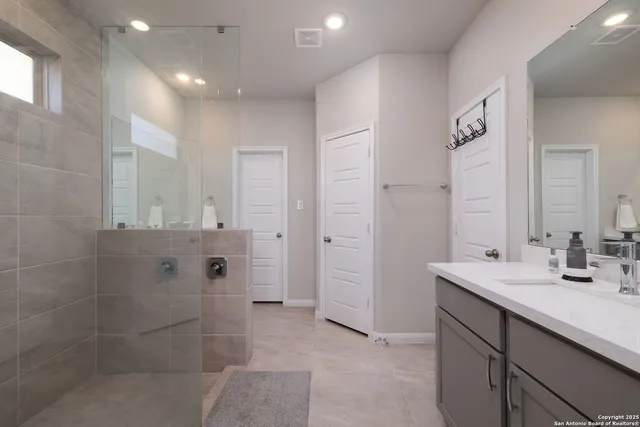 a bathroom with a double vanity sink mirror and shower