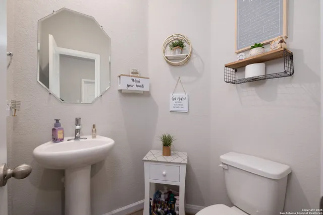 a bathroom with a sink mirror and toilet