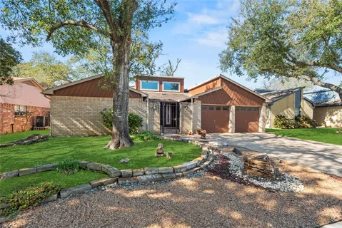a front view of a house with a garden and yard