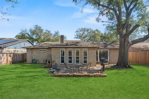 a view of a house with a yard and a patio